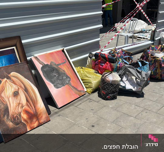 תמונות וציורים מונחים על הרצפה ליד שקיות צבעוניות